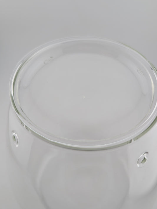 A close-up of a clear glass container or jar showing the top rim.
