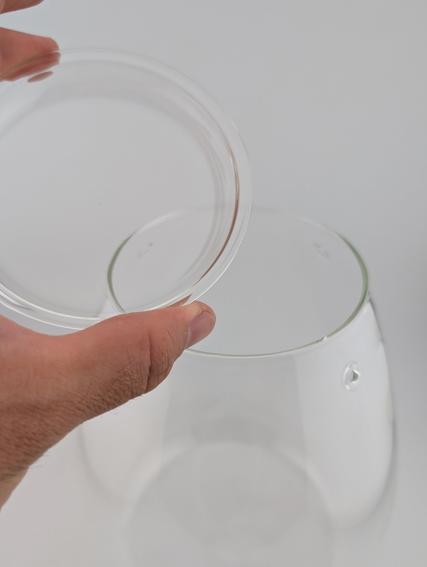 Clear glass lid next to a clear glass pot.